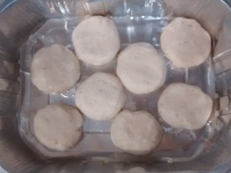 Photograph of eight round dumplings on an aluminium tray